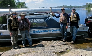 group of four men with canoe shuttle service boat