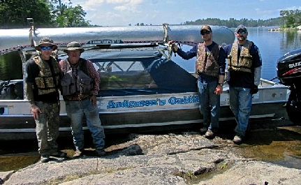 photo of a boat shuttle with five canoes loaded on top